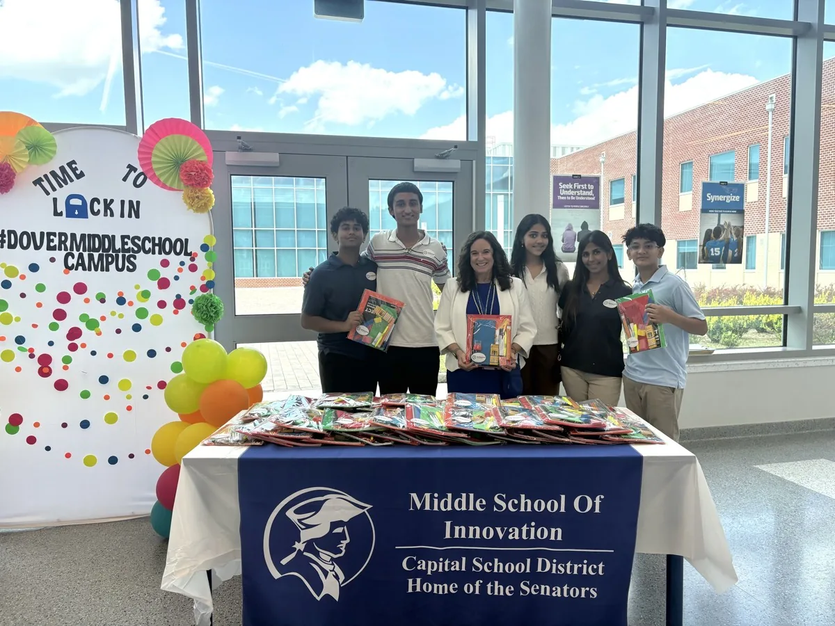 Delaware Secretary of Education Cindy Marten holding a supply kit with SkillSphere students at the Dover Middle School campus.