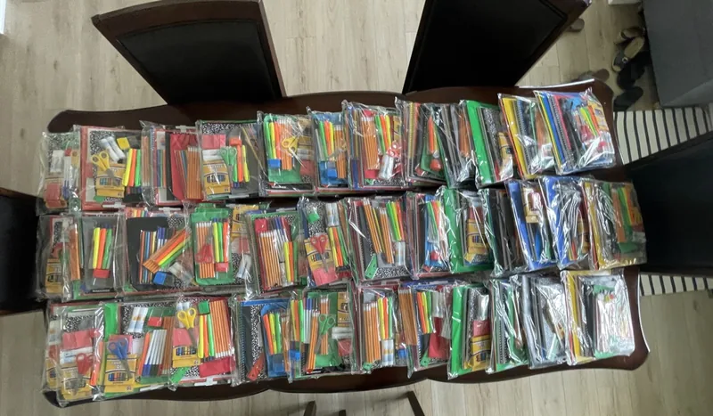Boxes of donated school supplies stacked and ready for packing.