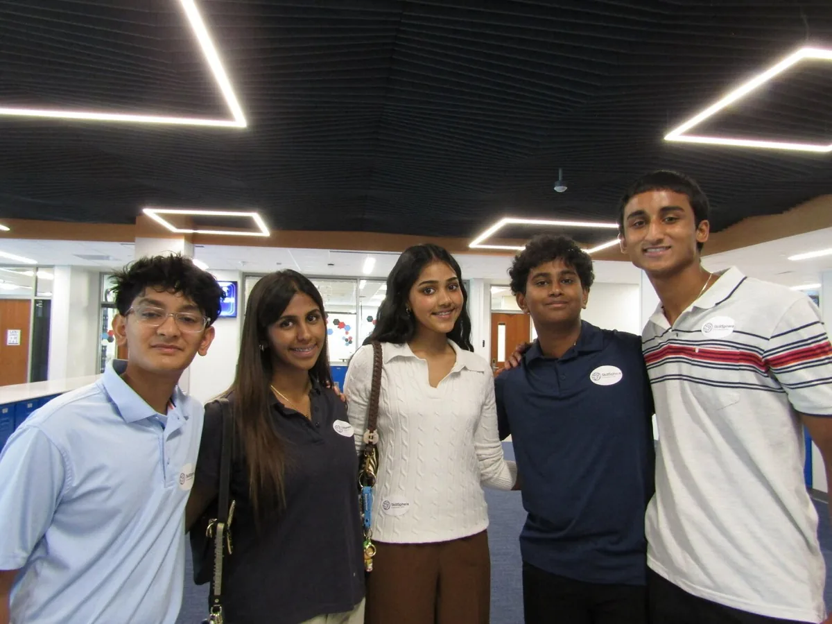 Five SkillSphere team members wearing name badges at an evening event.