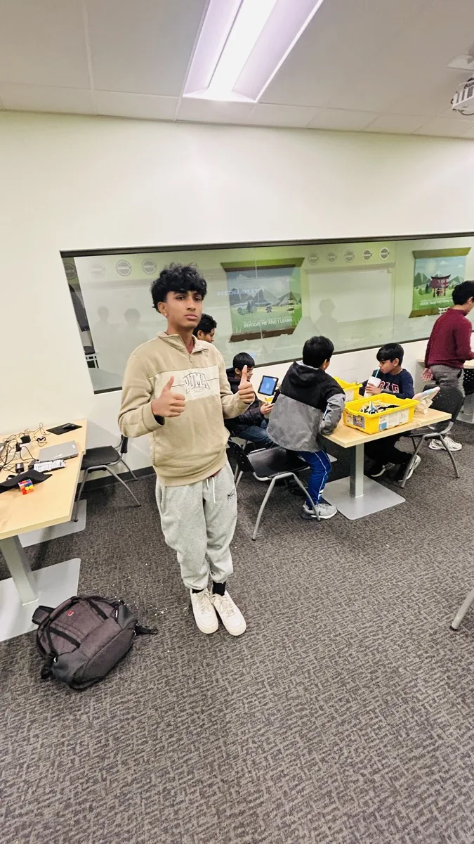 A student standing at the front of a classroom leading a workshop session.